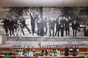 um grupo de pessoas pulando na frente de um mural em Hard Days Night Hotel em Liverpool