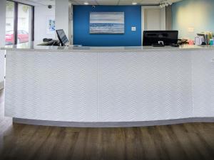 einem großen weißen Tresen in einem Büro mit blauer Wand in der Unterkunft Tropical Seas Hotel in Myrtle Beach