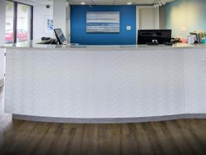 a large white counter in an office with a blue wall at Tropical Seas Hotel in Myrtle Beach