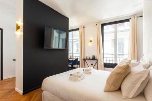 um quarto com uma cama branca e uma parede preta em CMG Champs Elysees - Boetie 5 em Paris