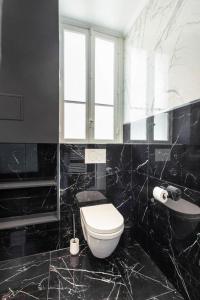 uma casa de banho em preto e branco com um WC e um lavatório em CMG Champs Elysees - Boetie 5 em Paris