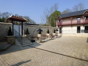 a group of benches sitting outside of a building at Le Moulin des Marais in Gaillon