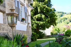 una casa con una pared de piedra y un patio en Chambres d'hôtes Les Ecrins, en Orbey