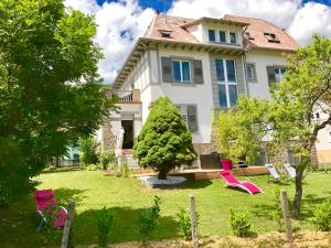 奧爾貝的住宿－Chambres d'hôtes Les Ecrins，院子里带粉红色椅子的房子