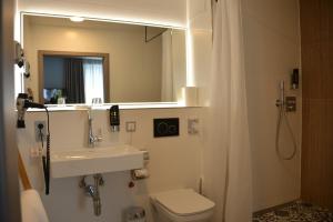 a bathroom with a sink and a toilet and a mirror at Belle Blue Zentrum in Munich