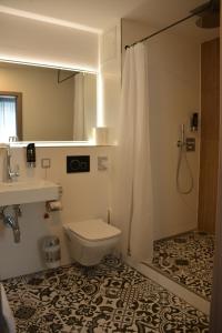 a bathroom with a toilet and a sink and a shower at Belle Blue Zentrum in Munich