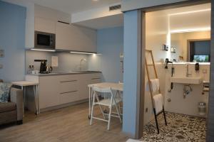 eine Küche und ein Wohnzimmer mit einem Tisch und einem Waschbecken in der Unterkunft Belle Blue Zentrum in München
