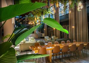 un ristorante con un lungo tavolo e sedie in legno di Hotel WICC a Wageningen