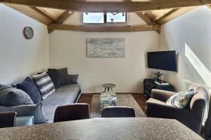 a living room with a couch and a tv at Lovely Somerset Getaway in Taunton