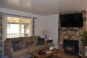 a living room with a couch and a stone fireplace at The Quail's Nest in Three Rivers