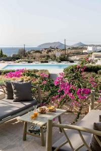 eine Terrasse mit einem Tisch, Blumen und einem Pool in der Unterkunft Stagones Luxury Villas in Ampelas