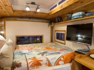 ein Schlafzimmer mit Bett und Flachbildfernseher in der Unterkunft Tauber Glamping Mobil in Tauberbischofsheim