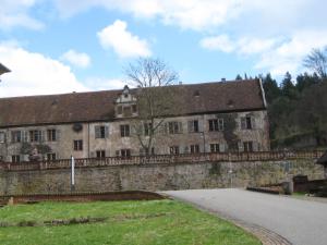 ein altes Steingebäude mit einem Zaun darum in der Unterkunft Tauber Glamping Mobil in Tauberbischofsheim