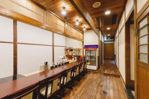 松本的住宿－Couch Potato Hostel，餐厅里设有长长的酒吧,铺有木地板