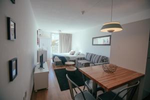 uma sala de estar com uma cama, uma mesa e cadeiras em Rentline Apartamentos - Skyline em Montevidéu