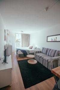 sala de estar con sofá y cama en Rentline Apartamentos - Skyline, en Montevideo