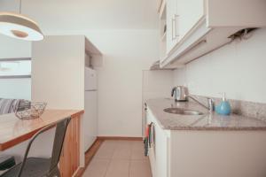 a kitchen with white cabinets and white appliances at Rentline Apartamentos - Skyline in Montevideo