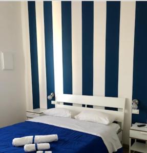 パレルモにあるBedroom la stazioneのベッドルーム1室(青と白のストライプの壁)