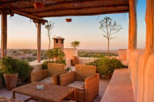 a patio with chairs and a table and a view at Tagadert Lodge in Oumnas