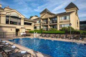 a house with a swimming pool in front of a building at Toftrees Golf Resort in State College