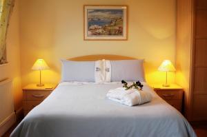 um quarto com uma cama branca com dois bichos de peluche em The Long Range em Budleigh Salterton