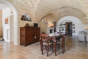 una cucina e una sala da pranzo con tavolo e sedie di Le Lantane - Luxury Rooms ad Alessano