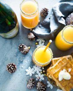 a table topped with waffles and two glasses of orange juice at La Playa Beach & Golf Resort, a Noble House Resort in Naples
