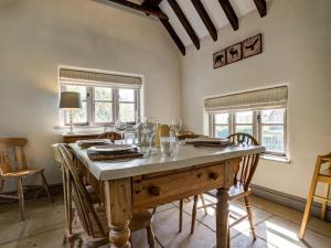 a dining room with a wooden table and chairs at Cosy Cot in Stoford