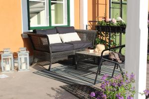- une terrasse couverte avec un canapé en osier et une table dans l'établissement Gamla Brukshandeln Bed&Breakfast, à Lövstabruk