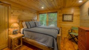 um quarto com uma cama num chalé de madeira em Row Harder em Blue Ridge