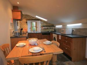 a large kitchen with a wooden table and chairs at Robbie's Barn in Halford