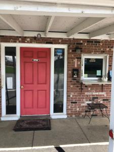 a red door on a brick building with a television at Harcourt Motel in Mount Vernon