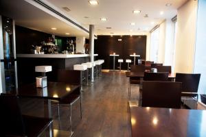 a restaurant with tables and chairs and a bar at Hotel Universal by Maxi Hoteles in Granada