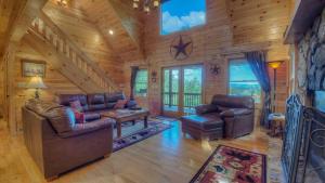 una sala de estar con muebles de cuero en una cabaña de troncos en Sunset Lodge, en Blue Ridge