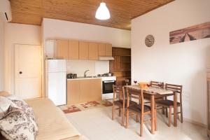 a kitchen and dining room with a table and chairs at Home Style Apartment in Lefkimmi
