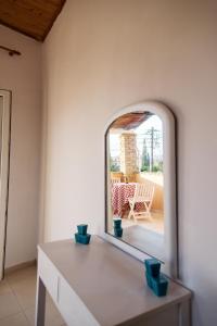 a room with a table and a window with a chair at Home Style Apartment in Lefkimmi +26 photos