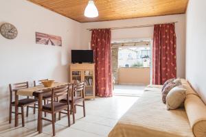 a bedroom with a bed and a table and chairs at Home Style Apartment in Lefkimmi