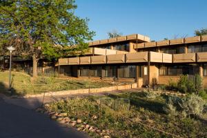 a large brick building with a tree in front of it at Kachina Lodge - Inside the Park in Grand Canyon Village