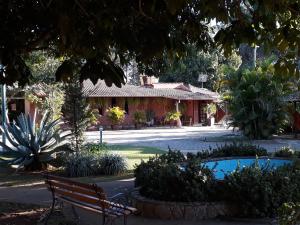 eine Parkbank vor einem Gebäude in der Unterkunft Pousada Pontal do Lago in Carmo do Rio Claro