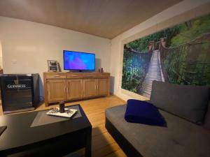 ein Wohnzimmer mit einem Sofa und einem Flachbild-TV in der Unterkunft Ferienwohnung Eva und Alexander in Hirschbach