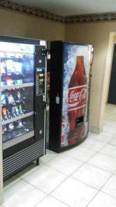 an open cocacola refrigerator next to a soda machine at Intown Suites Extended Stay Newport News VA - North in Newport News