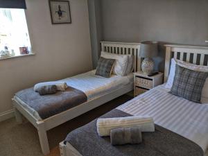 a bedroom with two beds and a lamp and a window at Park House in Ingleby Arncliffe