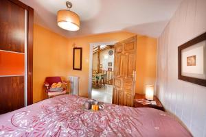 - une chambre avec un lit et une couverture rose dans l'établissement Alojamiento Rural Pueblo de la Ribera, à Peñafiel