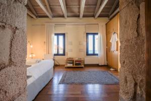 - une chambre avec un lit, 2 fenêtres et un tapis dans l'établissement Loft Chania, à La Canée