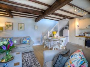 een woonkamer met een bank en een tafel bij Bobble Cottage in Bourton on the Water