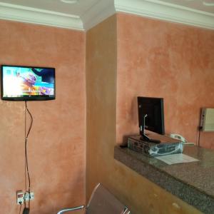 a hotel room with a tv on a wall at LARRYDAM HOTEL AND SUITES in Ilesa
