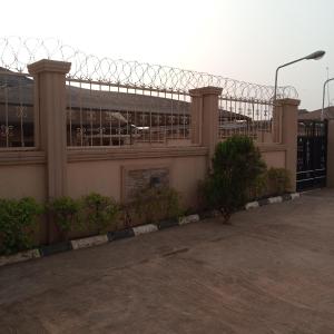 ein Gebäude mit einem Stacheldrahtzaun und einem Gebäude in der Unterkunft LARRYDAM HOTEL AND SUITES in Ilesa