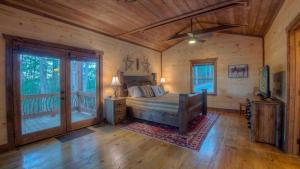 Un dormitorio con una cama en una cabaña de troncos en Triple Vista Mountain Tops, en Blue Ridge