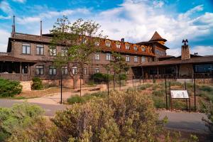 an old building with a fence in front of it at El Tovar - Inside the Park in Grand Canyon Village