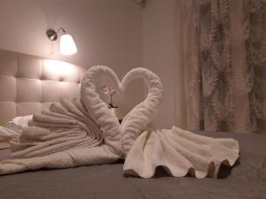 瓦西利基的住宿－Villa Delfini，两个天鹅被毯子裹在床上
